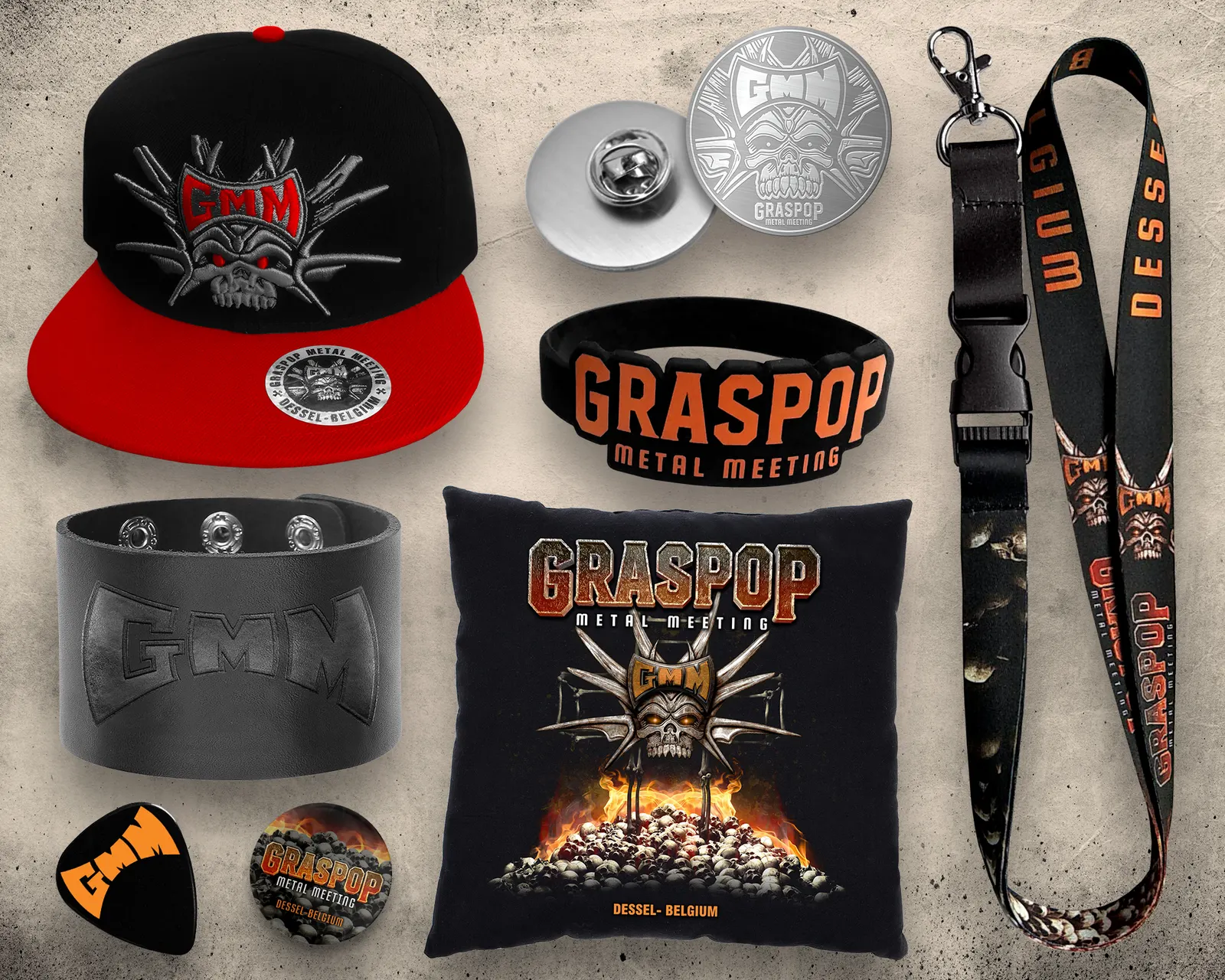 Graspop merch range: embroidered snapback, metal pin, silicone wristband, leather cuff, pillow, guitar pick, button and lanyard